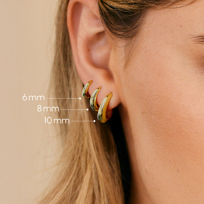 Astra Teardrop Huggies — Close-up of ear with three gold hoop earrings of different sizes, labeled with diameters.