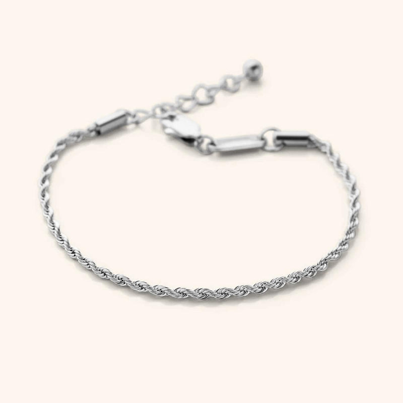 Flat lay of the silver Aurelia Rope Bracelet that features a woven chain pattern.