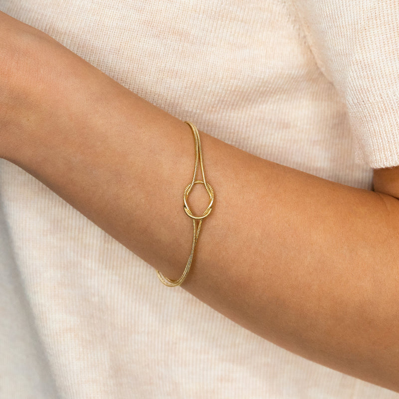 Aurelle gold knot bracelet worn on wrist