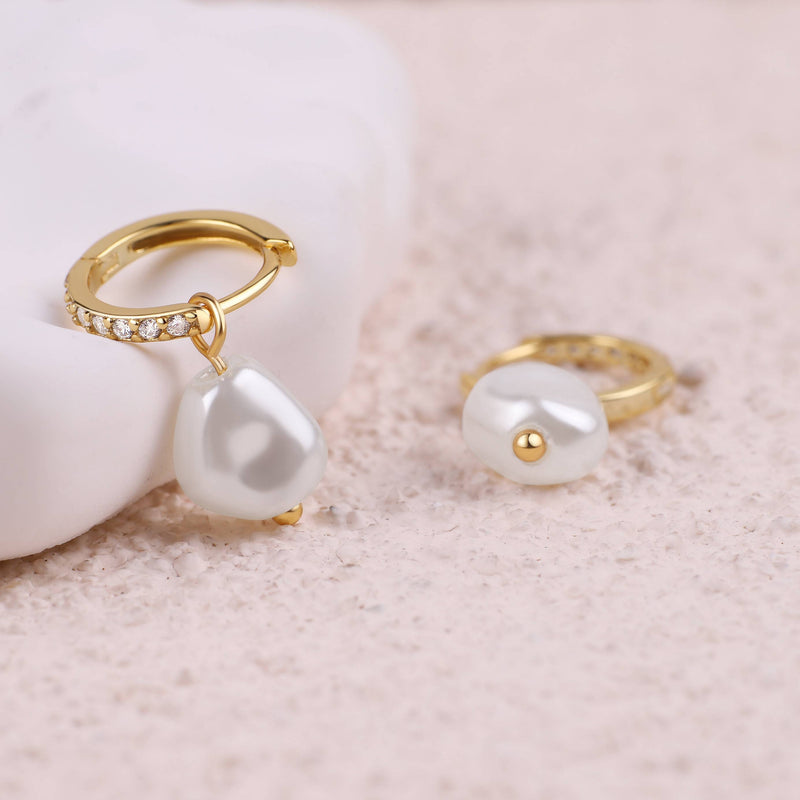 Eira gold freshwater pearl huggies on a neutral surface