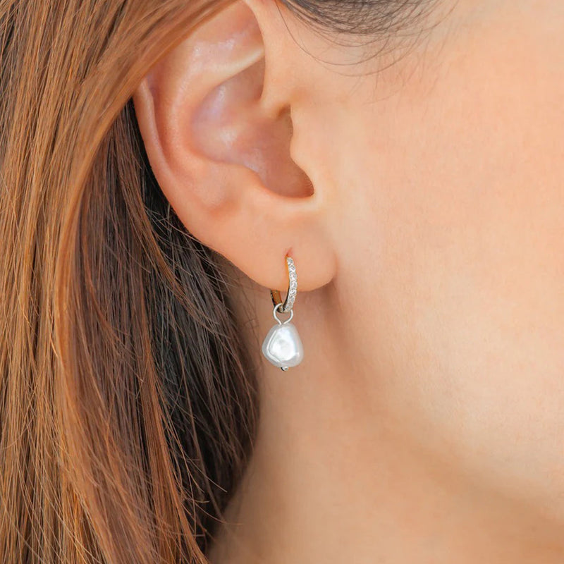 Eira silver freshwater pearl pavé huggie worn in an ear