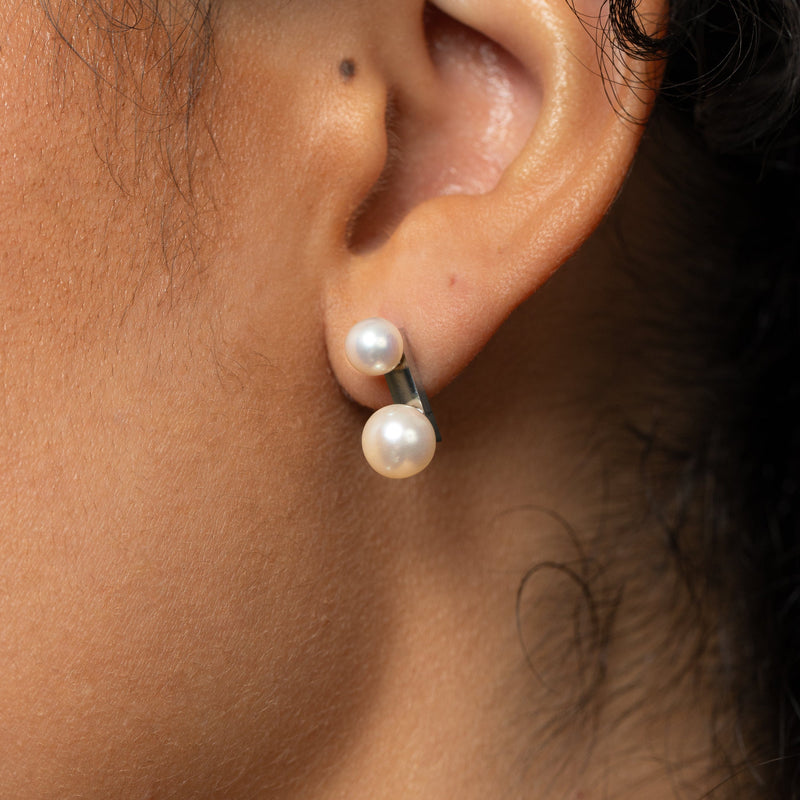 Close-up of an ear wearing a silver Luna Double Pearl Studs