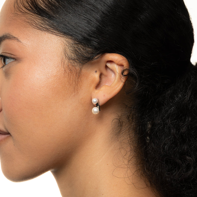 Close-up of a woman wearing silver Luna Double Pearl Studs