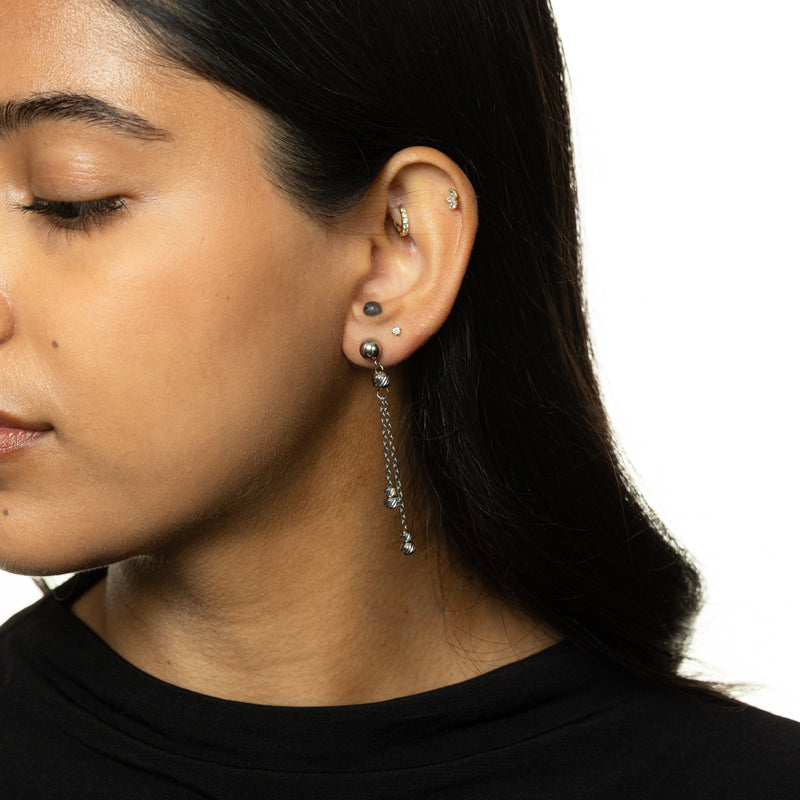 Woman wearing silver Noor Chain Drop Earrings with dual chains and ribbed beads.