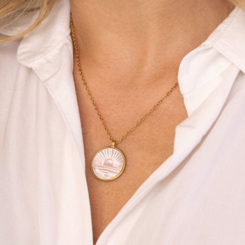 Solene gold-tone sunrise pendant worn on model