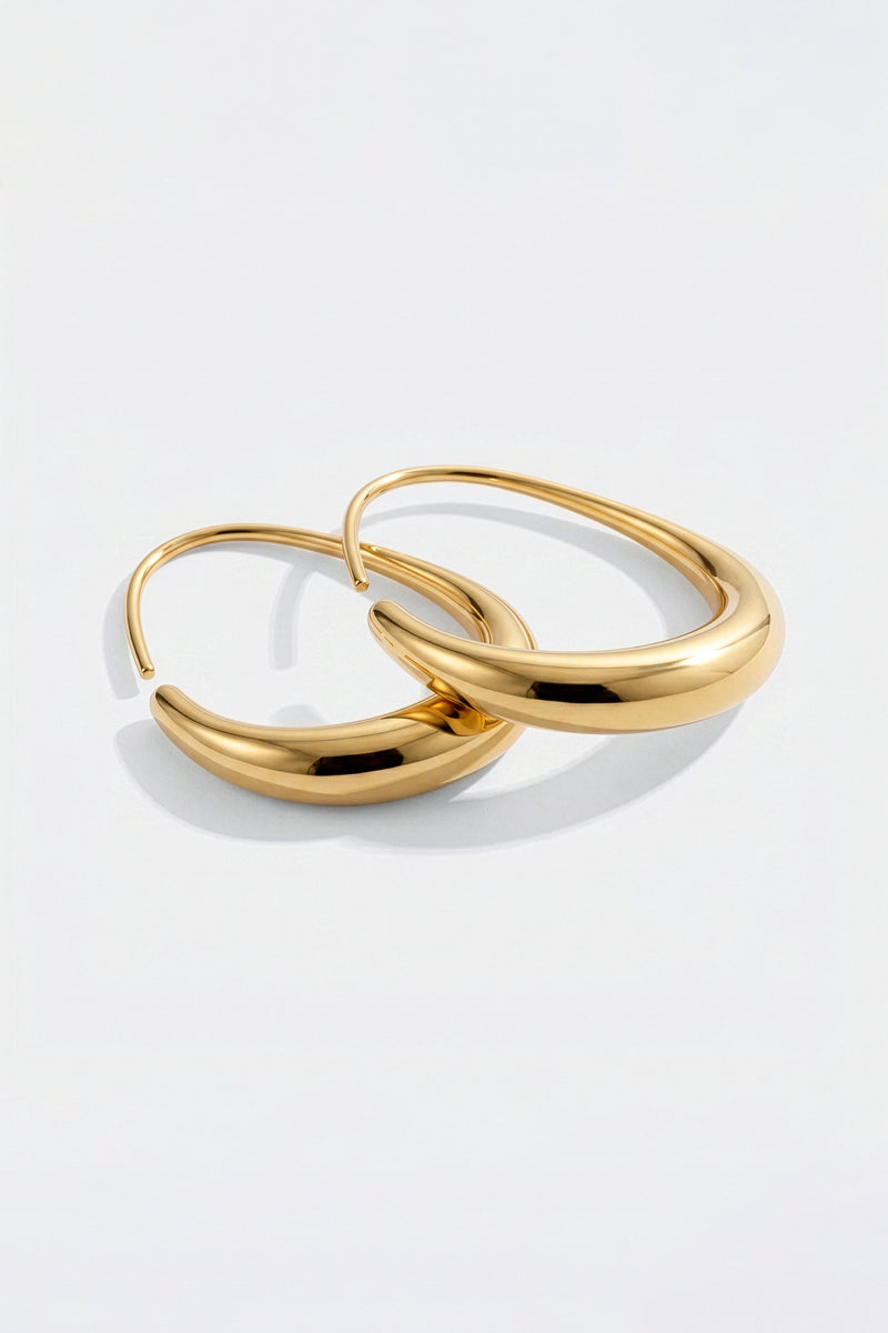 Solis gold fluid hoop earrings flat lay