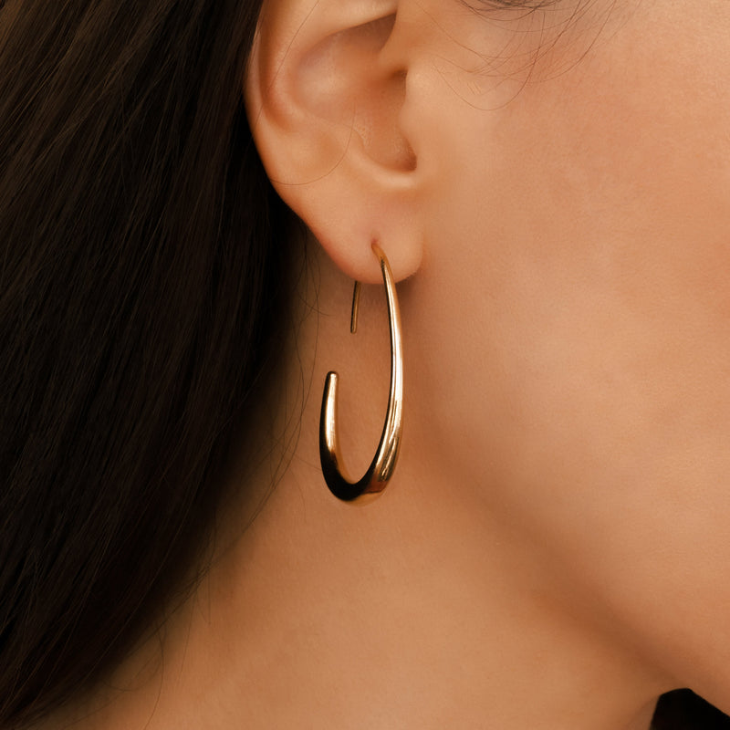 Solis gold fluid hoop earrings worn