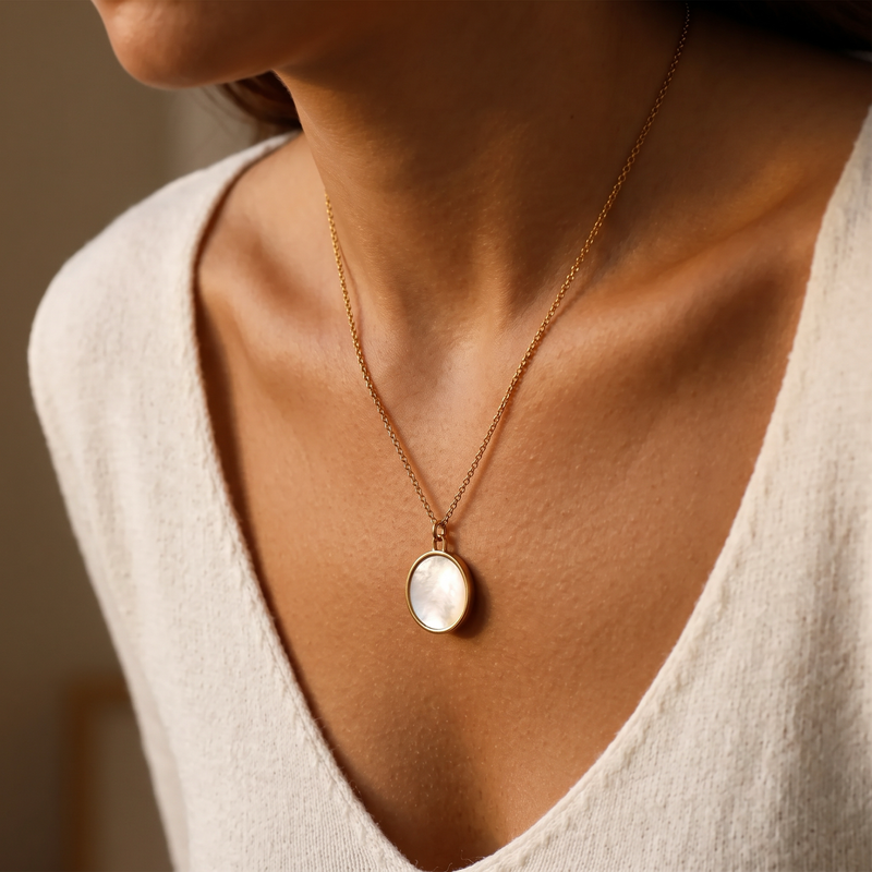 Vesper mother-of-pearl locket worn at the neckline